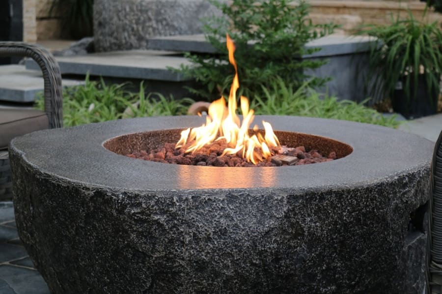 Gartentisch mit Kamin in Form eines Gaskamins aus Stein